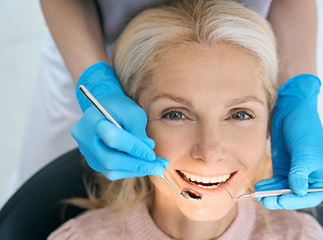 Woman smiling while giving thumbs up in dental chair